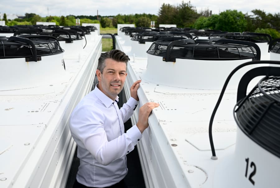 Coops energichef, Nicki Pagh Børgesen, står ved Coops ferskvarelager i Brøndby, Solmarksvej. Det 35.000 m2 store lagerareal med dagligvarer skal holdes koldt, og i den proces bruger Coop store mængder energi på at nedkøle lagret. Overskudsvarmen bliver i dag genbrugt - hvor den førhen gik til spilde. Foto: Nicki Pagh Børgesen