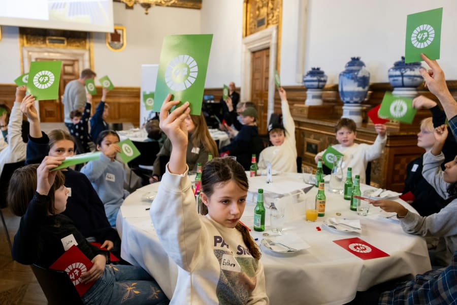 Børnene quizzer om en række udsagn om verdens tilstand – og med røde og grønne skilte i hænderne markerer de, om de tror, et udsagn er fake eller fakta. Foto: Jacob Crawfurd